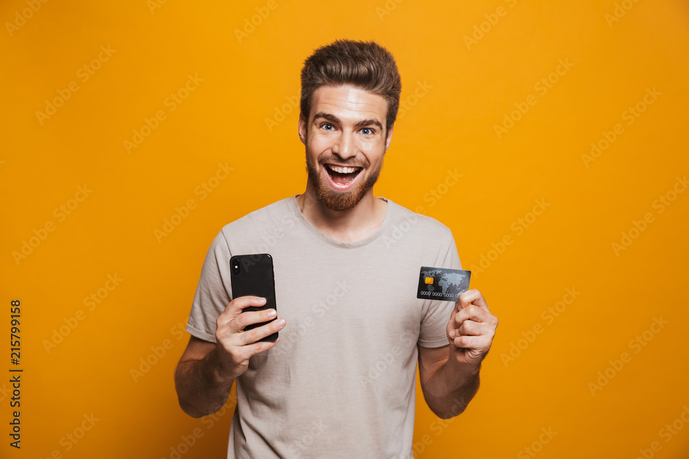 Portrait of a happy young man holding mobile phone