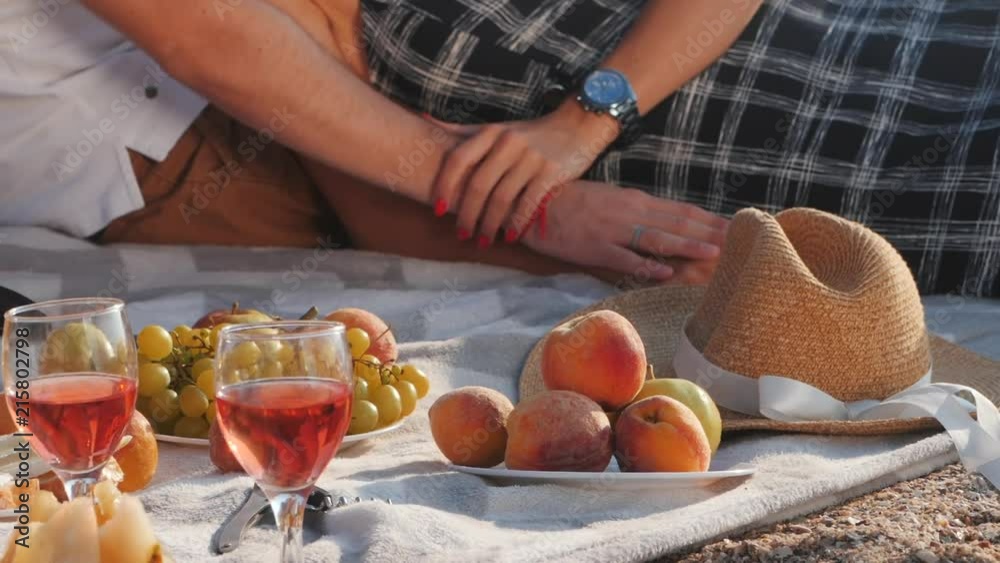 Unrecognizable young couple spending time on date together on the beach. Boyfriend and girlfriend on picnic. They relaxing, love each other. Relationship concept. Unrecognizable young couple spending time on date together on the beach. Boyfriend and girlfriend on picnic. They relaxing, love each other. Relationship concept.