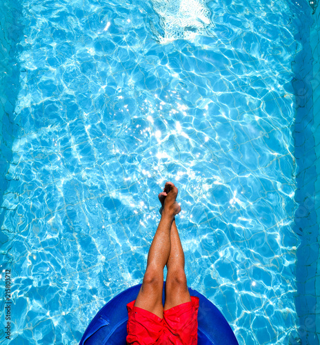 feet and body of a man in the pool on a swim tube, inner tube