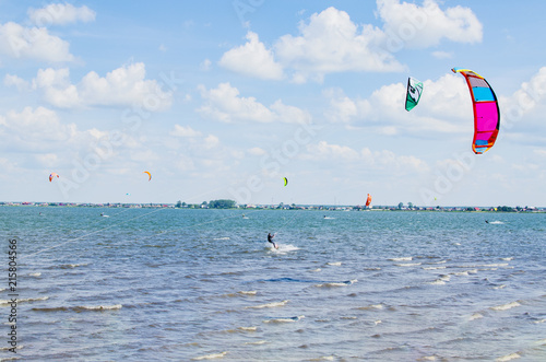 Sky surfers ride around the lake on a summer sunny day on the waves