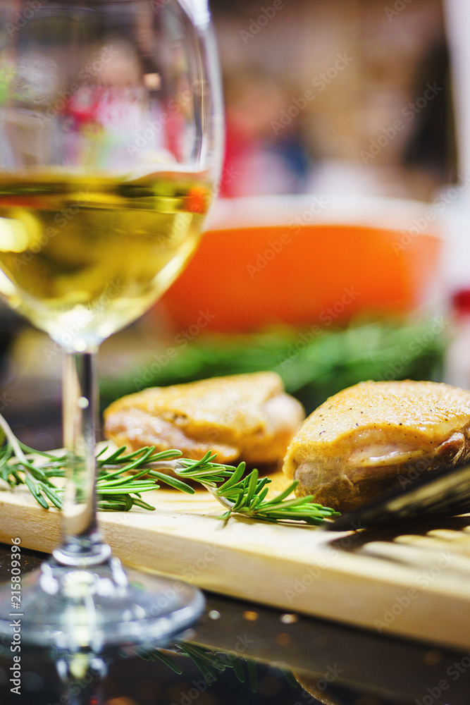 Cooked turkey breast in orange sauce on a wooden board with rosemary and a glass of wine. Cooked turkey breast in orange sauce on a wooden board with rosemary and a glass of wine.