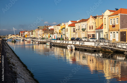 Canal de S  o Roque in the city of Aveiro  Portugal  flanked by colorful houses  boats anchored and in the background a moliceiro to pass under the bridge of Carcavelos.