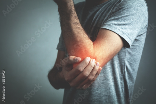 Caucasian man with elbow pain. Pain relief concept photo