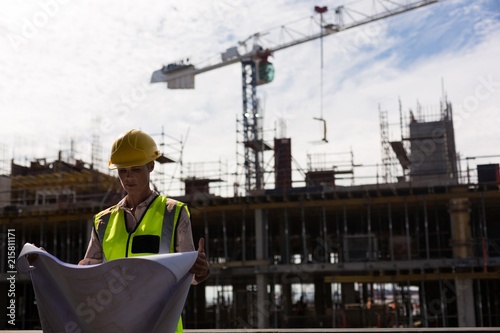 Female architect checking blueprint