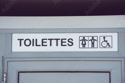 französische Toilettentür einer öffentlichen Toilette mit der Aufschrift 