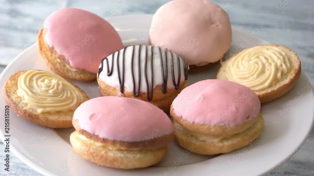 Plate with tasty glazed cookies. Set of delicious round biscuits with cream. Appetizing crispy dessert.