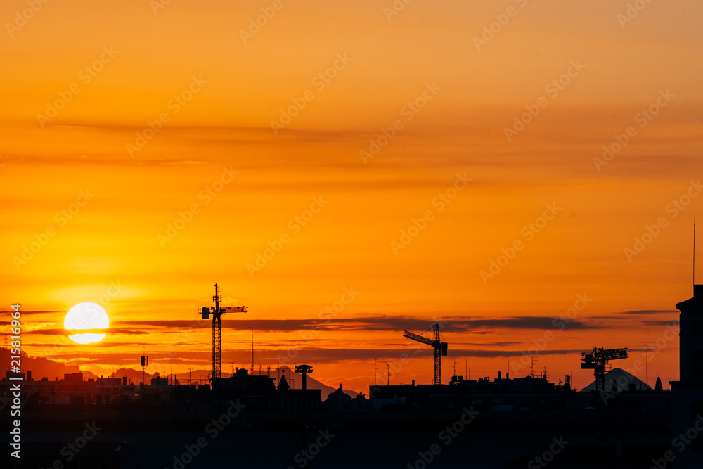 silhouette of construction cranes at sundown silhouette of construction cranes at sundown