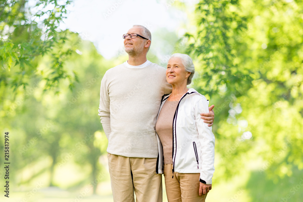 old age and people concept - happy senior couple hugging over green natural background