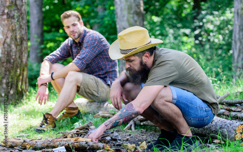 Masculinity concept. Ultimate guide to bonfires. How to build bonfire outdoors. Man brutal bearded hipster prepares bonfire in forest. Arrange the woods twigs or wood sticks. Men on vacation