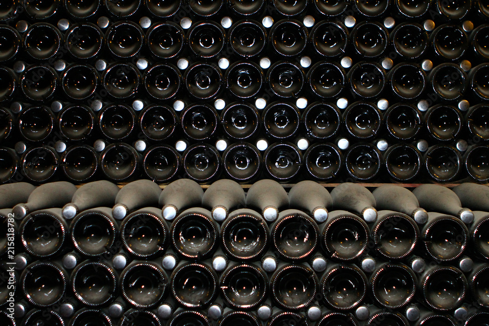 Champagne bottles, lying in the cold dark dusty wine cellar front view Champagne bottles, lying in the cold dark dusty wine cellar front view