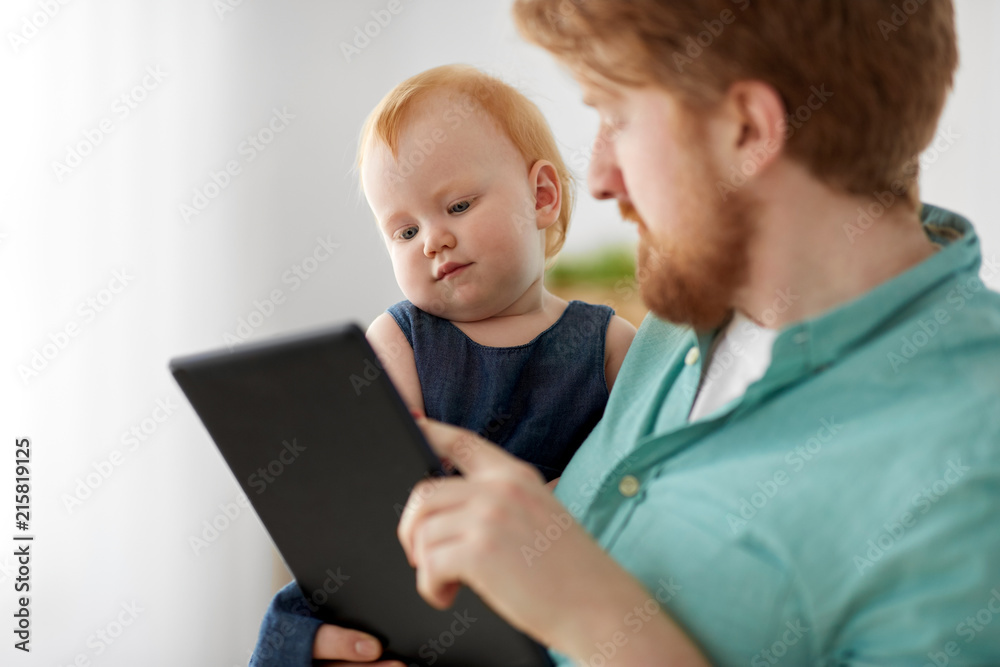 family, fatherhood and technology concept - happy red haired father and little baby daughter with tablet pc computer at home family, fatherhood and technology concept - happy red haired father and little baby daughter with tablet pc computer at home