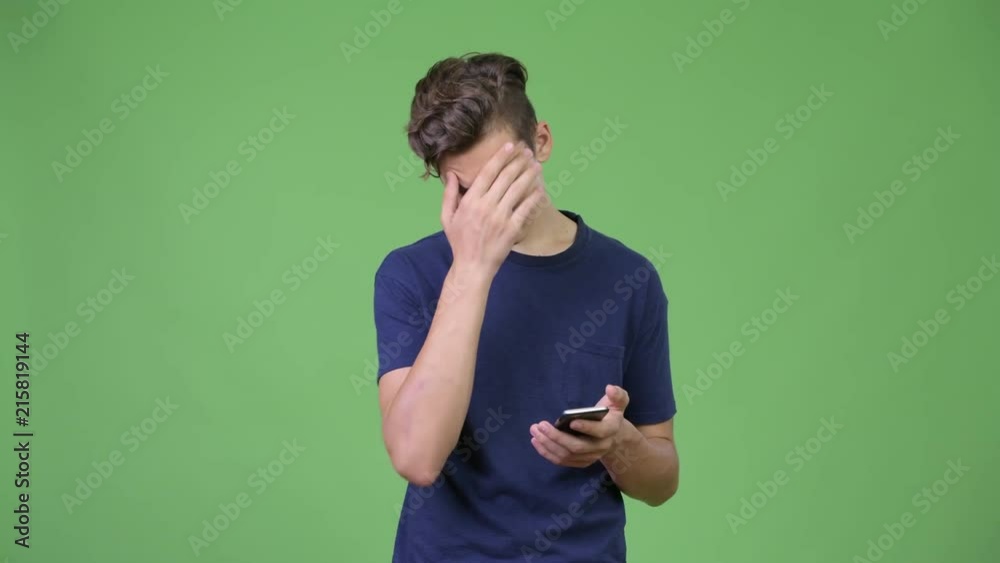 Young teenage boy using phone and getting bad news Young teenage boy using phone and getting bad news