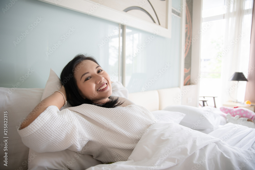 Cheerful woman wake up with fresh feeling in clean bedroom Cheerful woman wake up with fresh feeling in clean bedroom