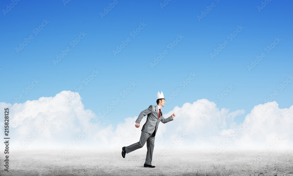King businessman in elegant suit running and blue sky at background