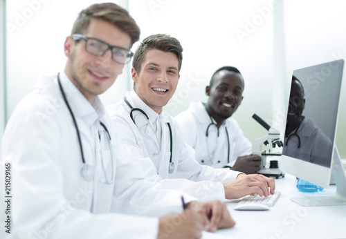 team of doctors sitting at the laboratory table