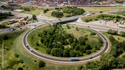 Aerial shot of a car moving on highway overpass, ringway, roundabout