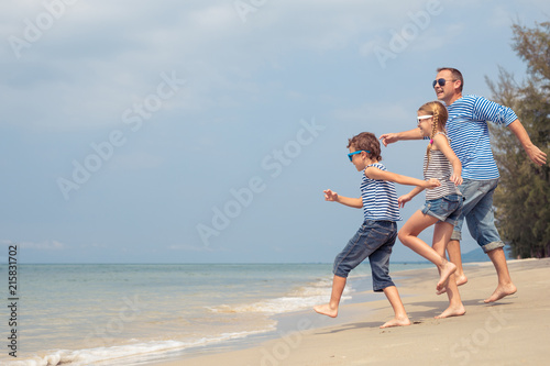 Father and children  playing on the beach at the day time.