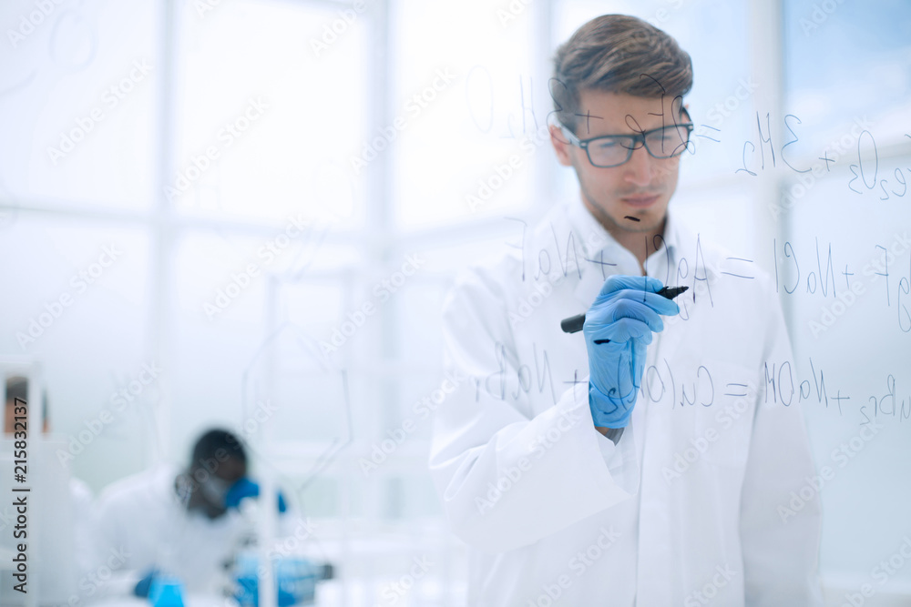 scientist making notes on the glass Board at the time of the experiment scientist making notes on the glass Board at the time of the experiment