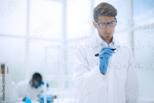 scientist making notes on the glass Board at the time of the experiment