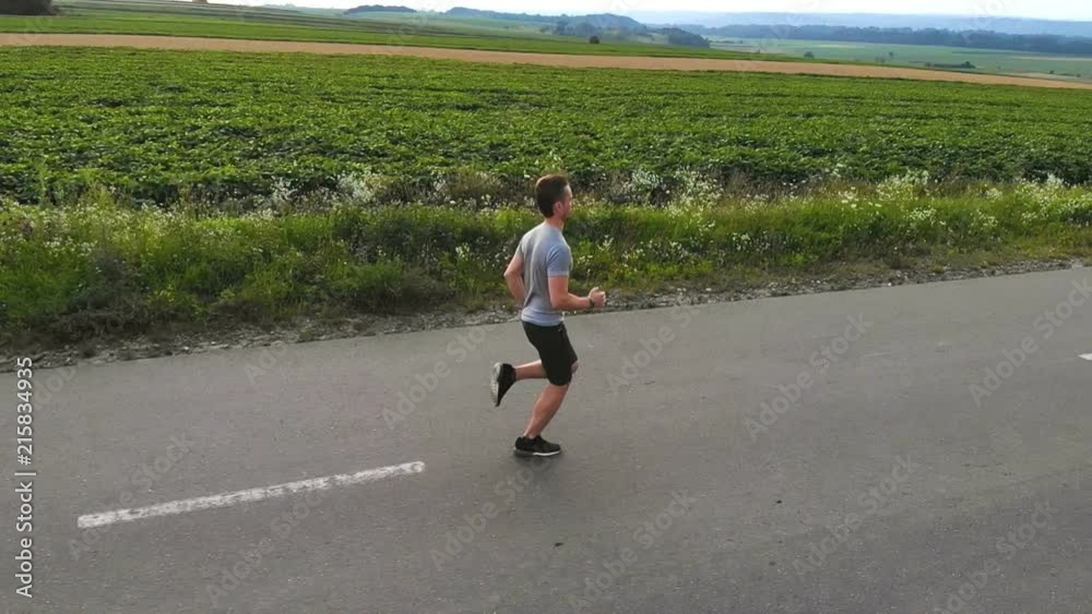 The man running on the road near field. slow motion The man running on the road near field. slow motion