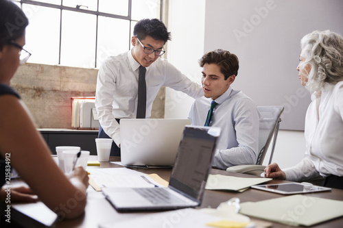 Two young male colleagues working together at a meeting