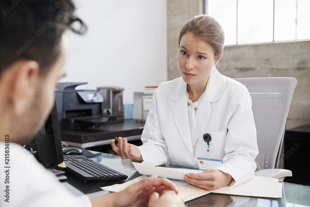 Concerned female doctor in consultation with male patient Concerned female doctor in consultation with male patient