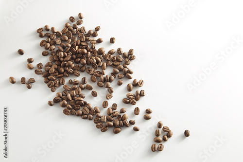 roasted coffee beans poured from clear glass