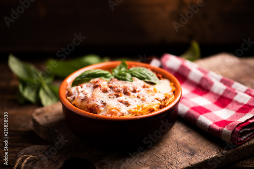 Traditional lasagne in a casserole dish on wooden table