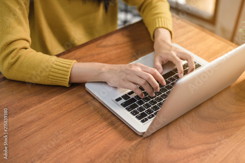 Canvas Print Close up of a young woman working with the laptop on a desk in coffee shop