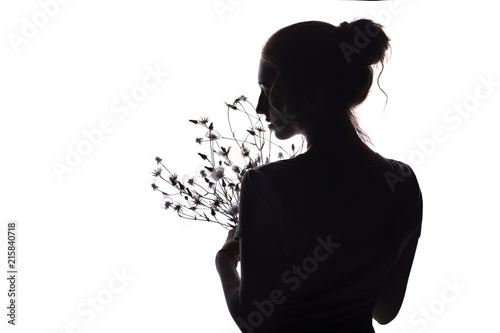silhouette profile of a beautiful girl with a bouquet of dried flowers on a white isolated background