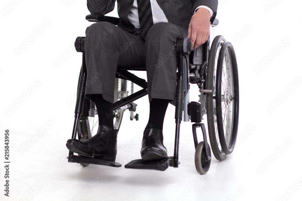 Obraz premium Cropped picture of disbaled man insuit. Studio shot of man sitting in wheelchair wearing fancy business outfit.