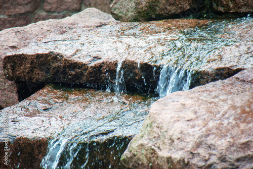 Closeup of water running down a couple of rocks