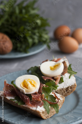 Sandwiches with whole grain bread, homemade cheese, arugula, ham and egg. Healthy snack.