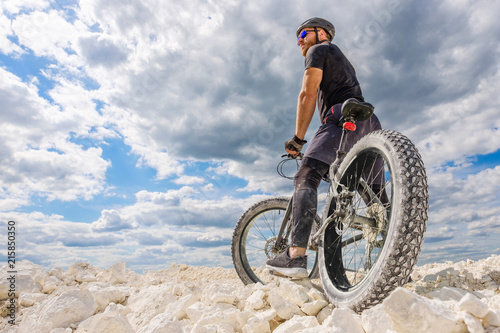 Training a bicyclist in a chalky quarry. A brutal man on a fat bike.  © Mikhail