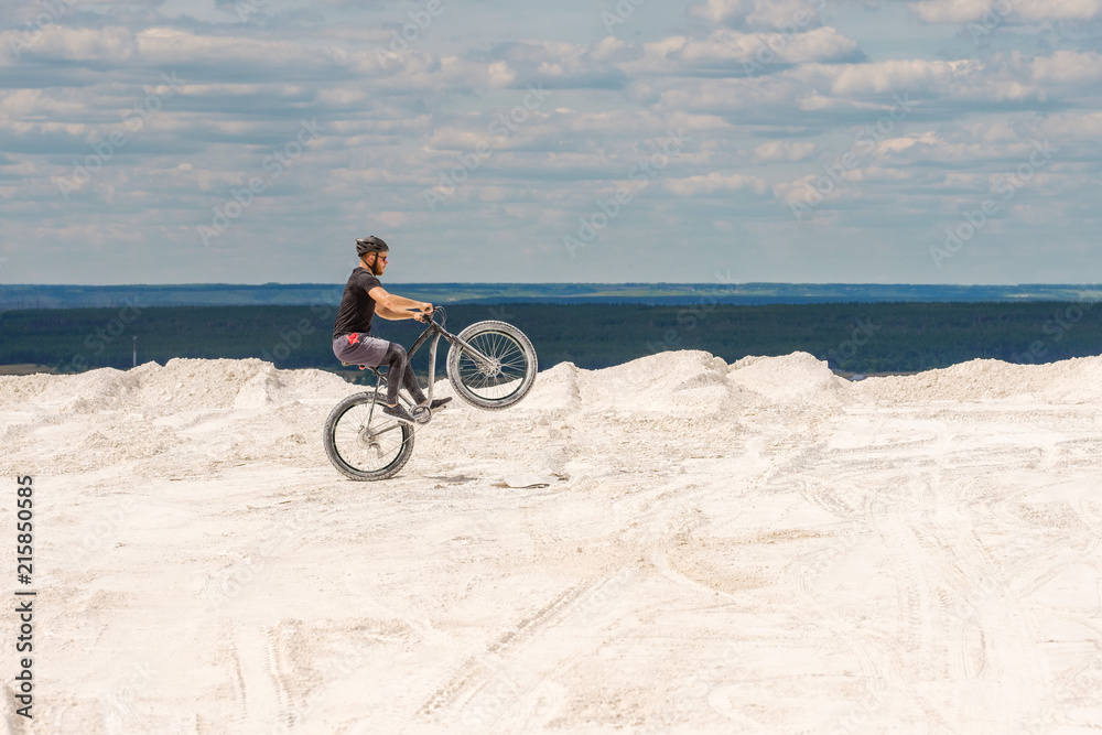 Fototapeta premium Training a bicyclist in a chalky quarry. A brutal man on a fat bike. 