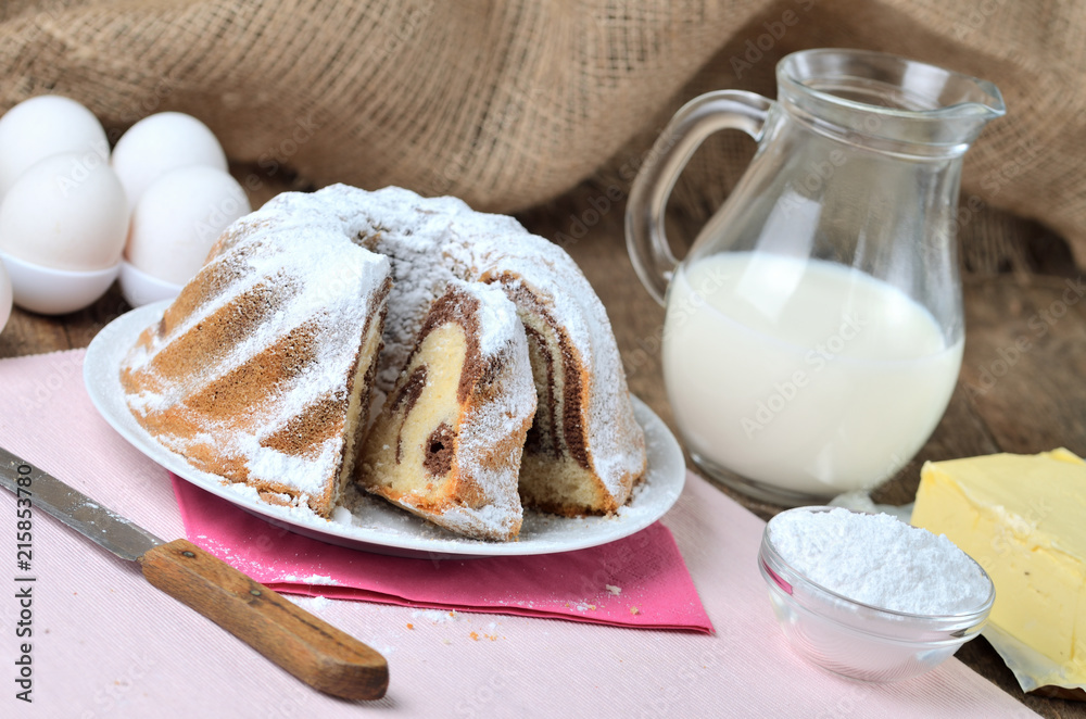 Cut of homemade marble cake sprinkled with sugar, lemon, melissa, milk, eggs and butter Cut of homemade marble cake sprinkled with sugar, lemon, melissa, milk, eggs and butter