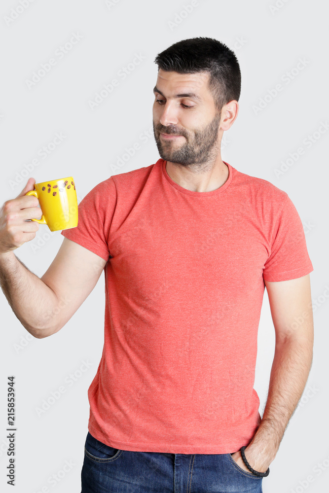 Studio portrait of young handsome man holding a cup of coffee