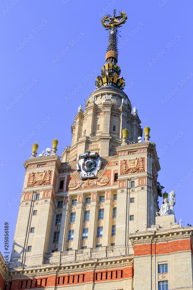 Fototapeta premium Building of Lomonosov Moscow State University (MSU) with national emblem of USSR and star on the spire against blue sky