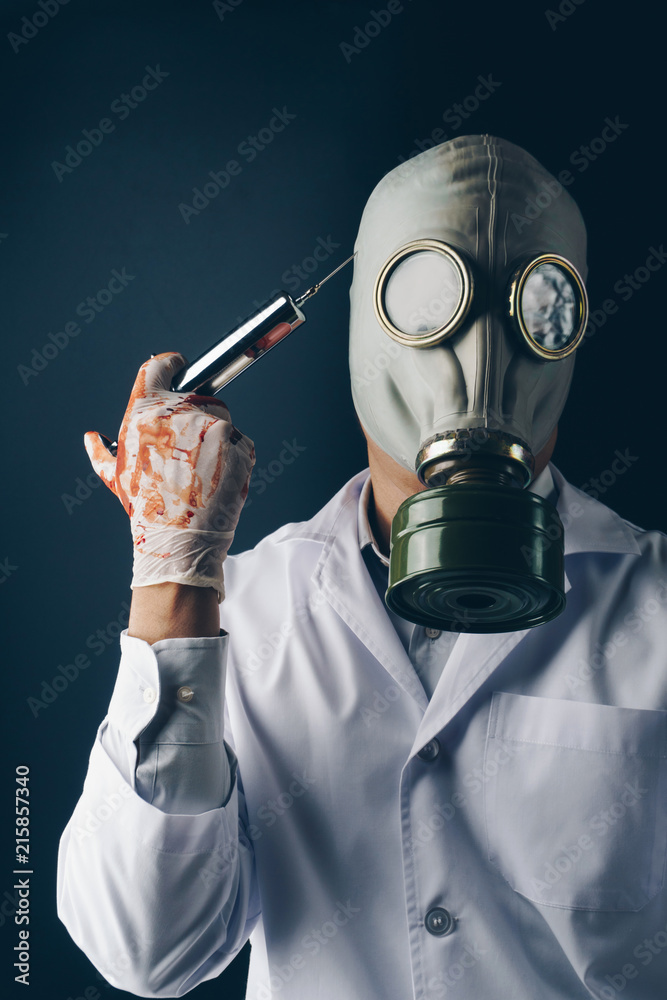 Creepy medical experiment concept, a scary doctor in gas mask wearing  bloody gloves with a big stainless steel syringe on dark background Stock  写真 | Adobe Stock