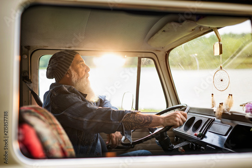 Senior hipster driving a van by countryside