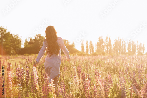 Woman at sunset flower field. Back view no face shot