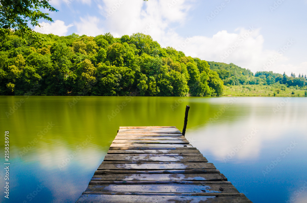 Wooden pier or jetty and a boat on lake sunset and sky reflection water. Wooden pier or jetty and a boat on lake sunset and sky reflection water.