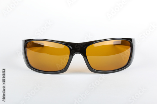 Sunglasses with black plastic frame and yellow glass on a white background © alexstepanov