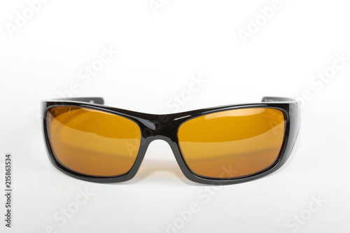 Sunglasses with black plastic frame and yellow glass on a white background