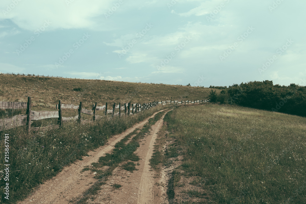 Empty country road with wooden fence