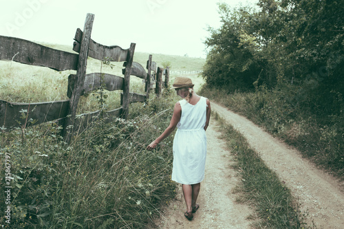 Woman walking alone on dirt road
