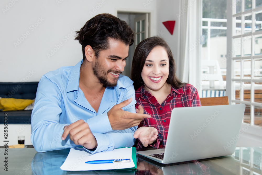 Arabic hipster men with laughing caucasian girlfriend at computer Arabic hipster men with laughing caucasian girlfriend at computer