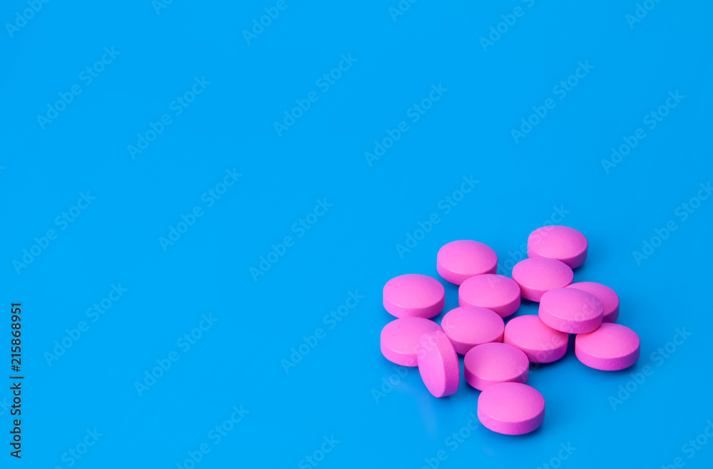 Bright pink pills on a blue background.