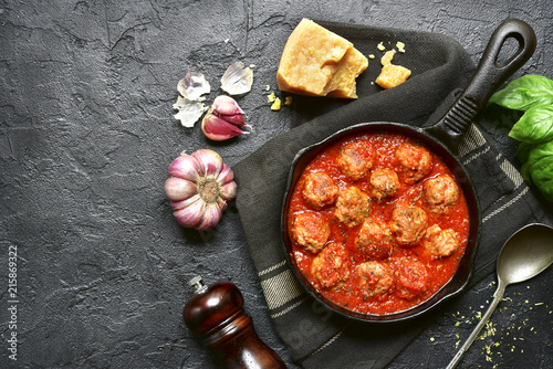 Spicy meatballs in tomato sauce in a cast iron pan.Top view with copy space.