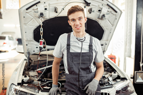 A young man is at work at a car service